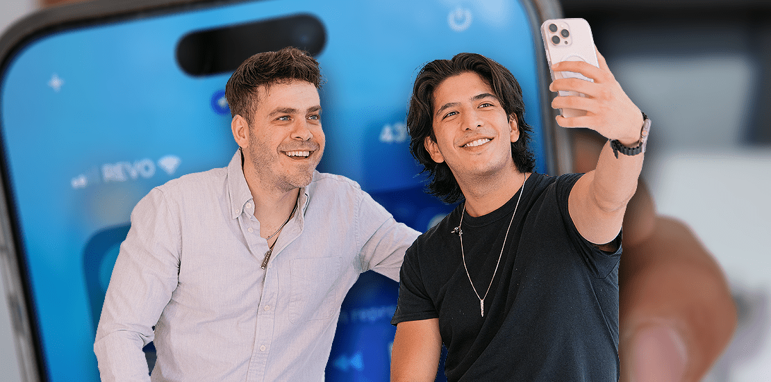 Content creators Jimmy Álvarez (left) and Andrés Neshudo (right) taking a selfie, with a smartphone in the background showing the REVO network carrier.